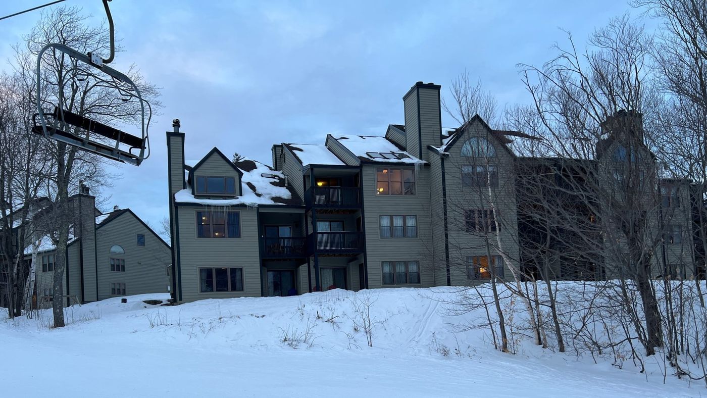 Winterplace Building F at Okemo seen from the chairlift, surrounded by snow-covered trees